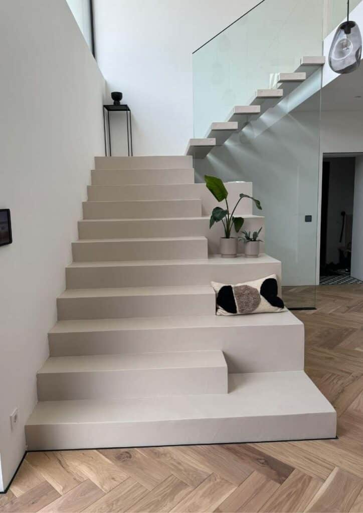 Moderne, fugenlose Treppe auf einem Parkettboden.