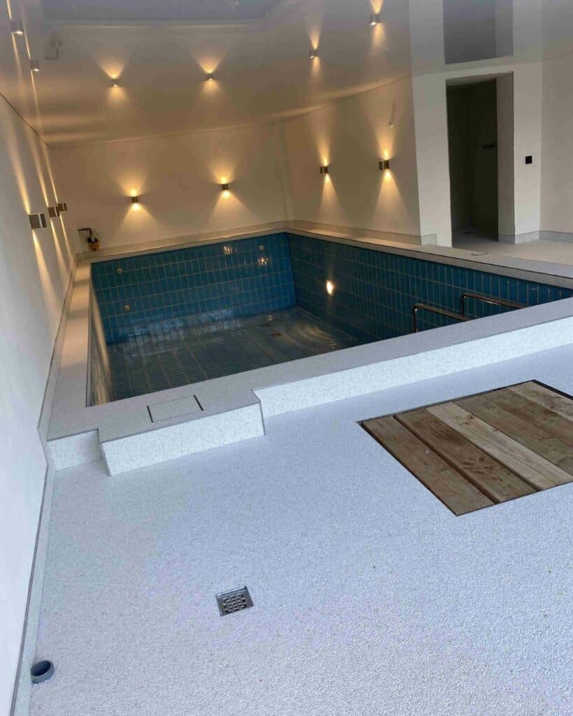 Weiße Steinteppichumrandung für den Innenpool.