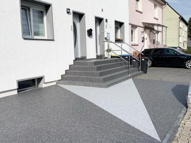 Steinteppich in Grau und Weiß am Hauseingang, moderne und robuste Bodenbeschichtung.