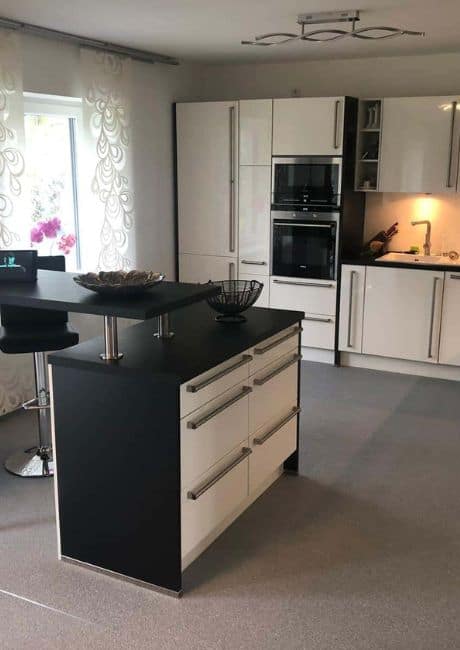 Kleinere Kueche mit einem grauen Steinteppichboden.