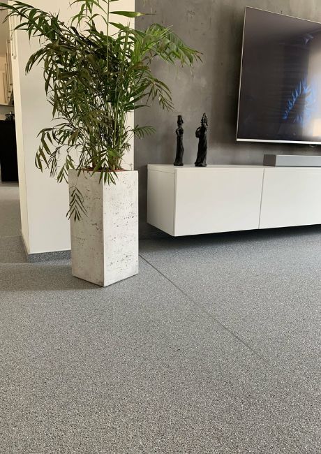 Wohnzimmer mit grauem Steinteppichboden.